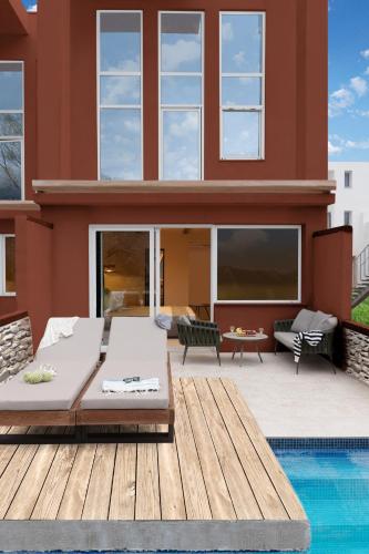 a house with a pool in front of it at Alexandra Golden Boutique Hotel-Adults Only in Chrysi Ammoudia