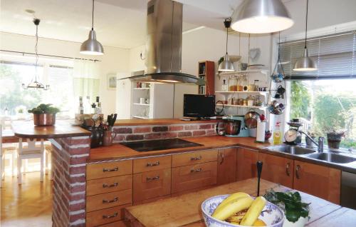 a kitchen with wooden cabinets and a bowl of bananas on a table at 4 Bedroom Stunning Home In Helsingborg in Helsingborg
