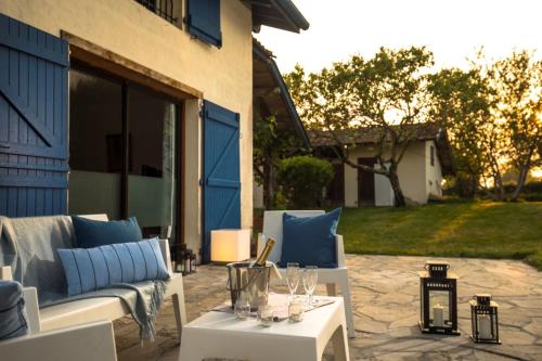 a patio with two couches and a table with wine glasses at Domaine d'Orx in Orx