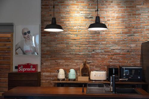 a brick wall with two lights above a counter at Boy apartment -Adult only in Hualien City
