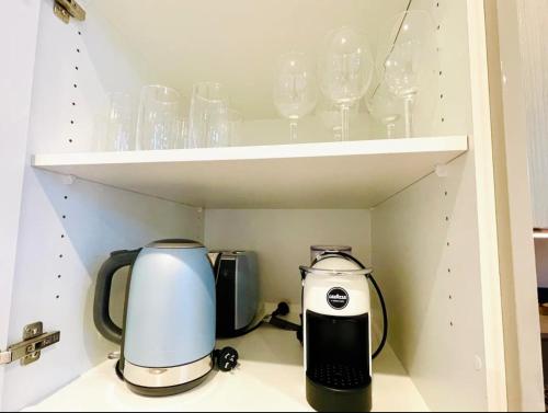 two coffee makers and glasses are sitting on a shelf at Charming and cozy 2 Bedrooms 2 bathrooms Condo with Study room, Parking, Wi-Fi in Sydney