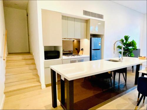 a kitchen with a large white island in a room at Charming and cozy 2 Bedrooms 2 bathrooms Condo with Study room, Parking, Wi-Fi in Sydney