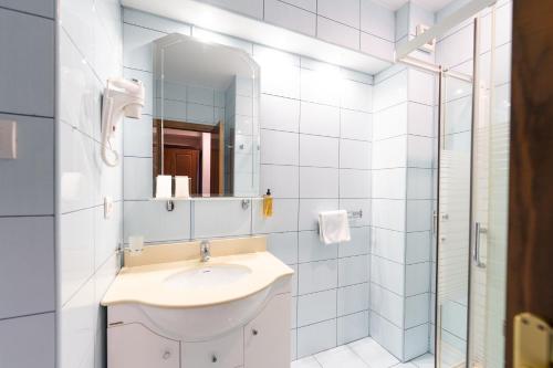 a white bathroom with a sink and a mirror at Hotel Ski&Sky in Predeal