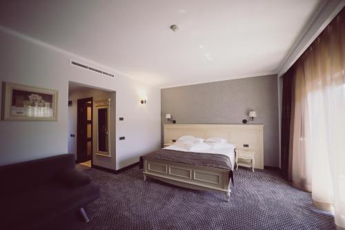 a bedroom with a bed with white sheets and pillows at Hotel Helen in Bacău