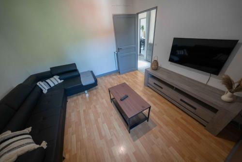 a living room with a large flat screen tv at La Villa du Pont Romain in Saint-Nectaire