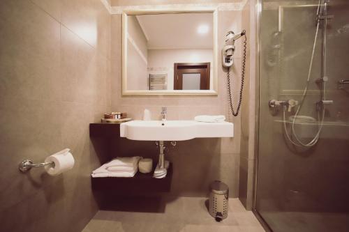 a bathroom with a sink and a shower at Hotel Helen in Bacău