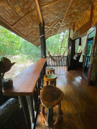 a room with a wooden table and two stools in a house at Floating Dreams in Tangkahan