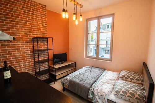 a bedroom with a bed and a brick wall at Studios Saint Jacques, Châtellerault in Châtellerault