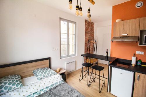 a room with a bed and a kitchen with a counter at Studios Saint Jacques, Châtellerault in Châtellerault
