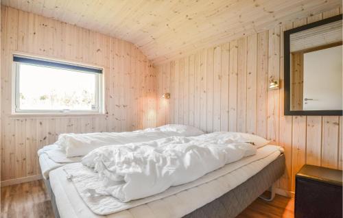 a bedroom with a white bed in a wooden wall at Holiday Home Vestensøvej Ebeltoft Iv in Ebeltoft