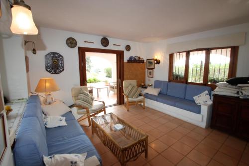 モライラにあるEl Barraco - sea view villa with private pool in Morairaのリビングルーム(青いソファ、テーブル付)