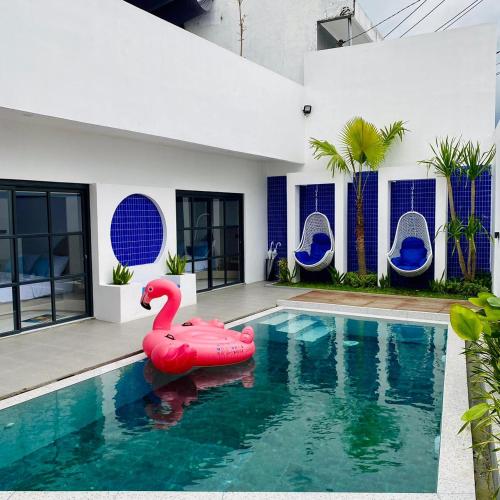 a pool with a red inflatable swan in the water at Fulton Avalon 3BR in Ngaglik
