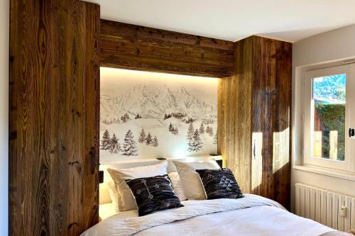 une chambre avec un grand lit avec un mur en bois dans l'établissement Le Woody - Bel appartement proche pistes de skis, à Megève
