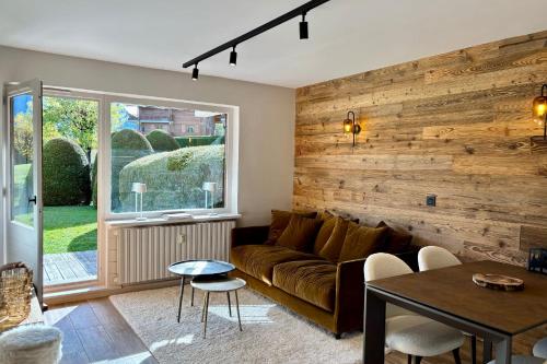 - un salon avec un canapé et un mur en bois dans l'établissement Le Woody - Bel appartement proche pistes de skis, à Megève