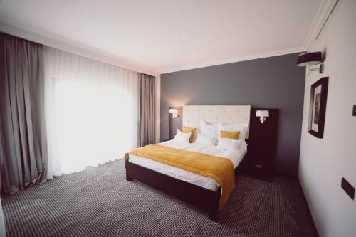 a bedroom with a bed and a large window at Hotel Helen in Bacău