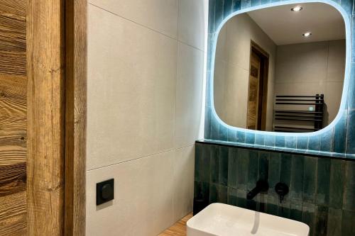 une salle de bain avec un lavabo et un miroir dans l'établissement Le Woody - Bel appartement proche pistes de skis, à Megève