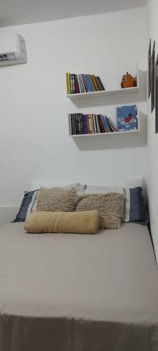 a bedroom with a bed with a book shelf at Studio 202 Cop 30 in Belém