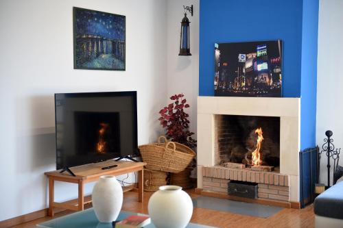 a living room with a fireplace and a tv at Villa Galiana By Florentia Homes in Toledo