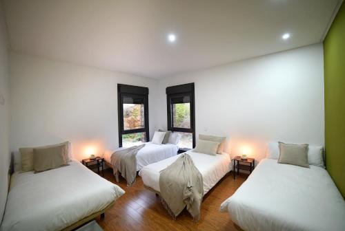 three beds in a room with three windows at Villa Galiana By Florentia Homes in Toledo