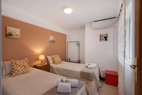a small room with two beds and a mirror at Villa Martina in Albufeira