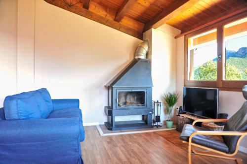 Una sala de estar con un sofá azul y una chimenea. en Unique natural place, Sallord, Llosa del cavall, en Sant Llorenç de Morunys