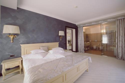 a bedroom with a large bed and a bathroom at Hotel Helen in Bacău