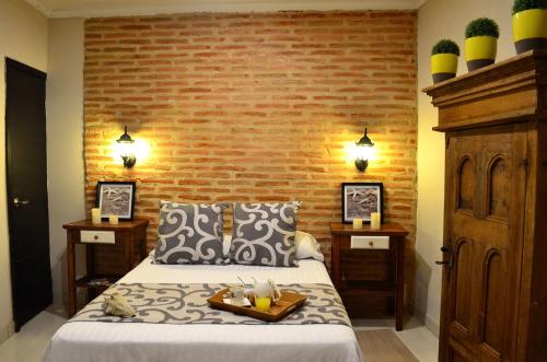 1 dormitorio con cama y pared de ladrillo en Hotel Galeria la Trinidad en Cartagena de Indias
