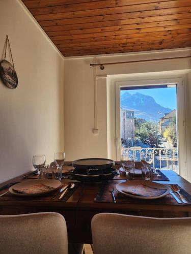 - une table à manger avec vue sur le patio dans l'établissement Le Flocon Petit Nid Douillet en Montagne, à Briançon