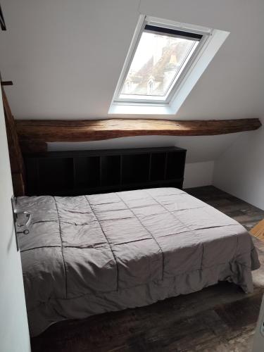 un lit dans une chambre avec une fenêtre dans l'établissement La Grange, à Avallon