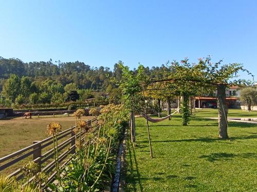 a field of grass with a fence and a tree at Dalpendre - Turismo em espaço rural in Felgueiras