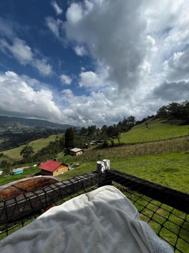 a bedroom with a view of a grassy hill at Glamping El Ocaso in Zipaquirá