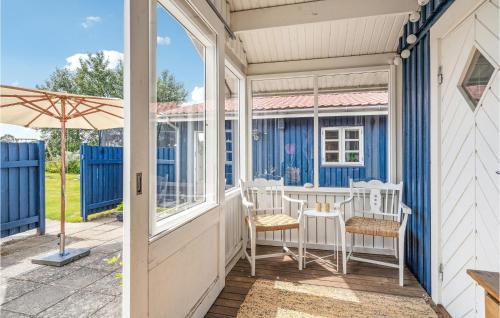 a porch with white chairs and an umbrella at Lovely Home In Mesinge With Wifi in Mesinge