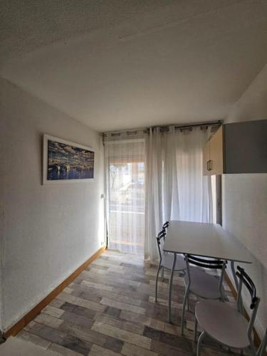 une salle à manger avec une table et des chaises et une fenêtre dans l'établissement Cap d'Agde bord de mer, au Cap d'Agde