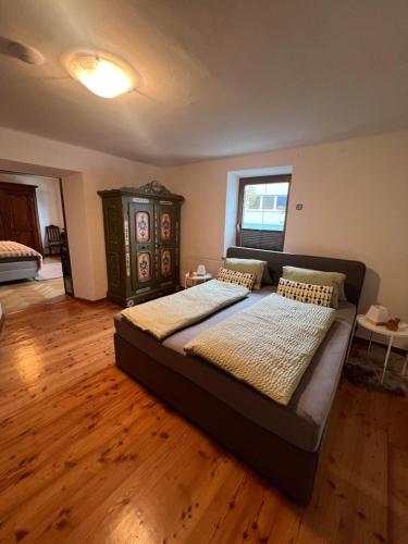 a large bed in a room with a wooden floor at Ferienwohnung Steinlicht in Lienz