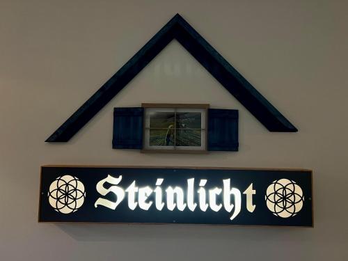 a sign on the side of a building with a window at Ferienwohnung Steinlicht in Lienz