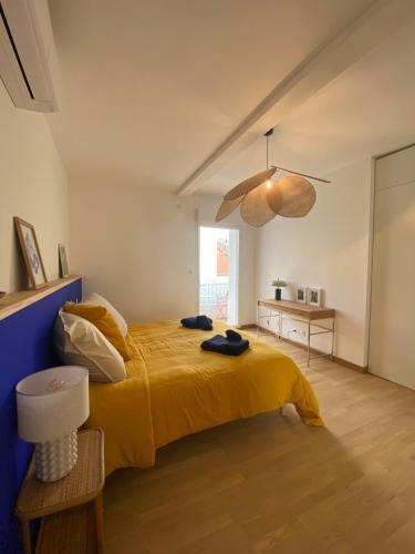 - une chambre avec un lit jaune et un mur bleu dans l'établissement Le Brassens, à Sète