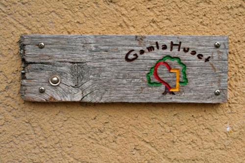 a wooden sign on the side of a wall at Ferienwohnung - Gamla Huset in Gamleby