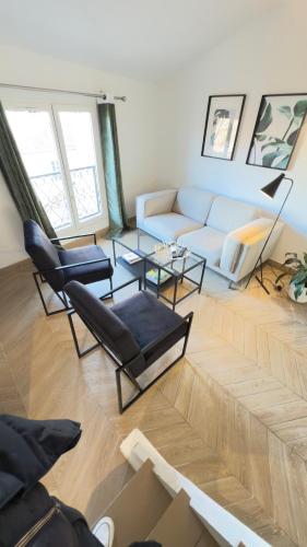 un salon avec un canapé blanc et des chaises dans l'établissement Appartement climatisé 2 chambres Centre historique, à Aix-en-Provence
