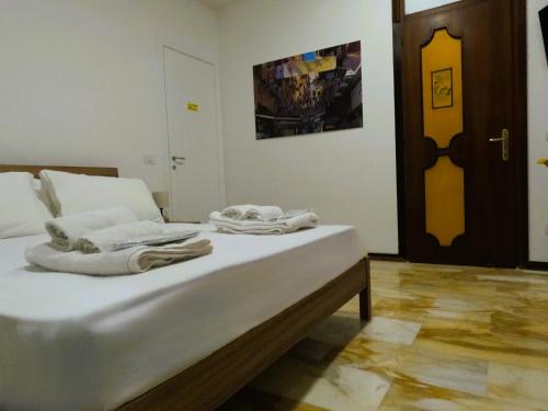 a white bed with towels on it in a room at Punto Felice Riviera - Centro Città Lungomare Caracciolo in Naples