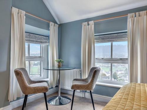a bedroom with a table and two chairs in front of a window at Bagshaw Mews in Bakewell