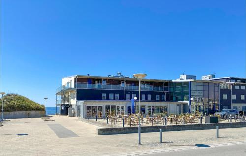 a building with tables and chairs in front of the ocean at 3 Bedroom Awesome Home In Falkenberg in Falkenberg