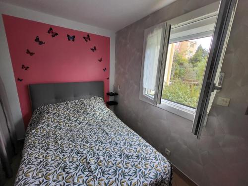 - une chambre avec un lit et une fenêtre avec des chauves-souris sur le mur dans l'établissement Le Cap D'agde appt T2, R d C , entièrement rénové, au Cap d'Agde