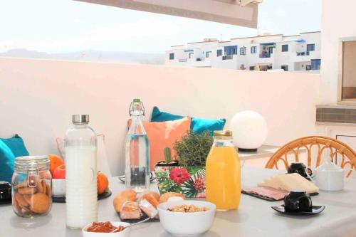 stół z butelkami mleka i sokiem pomarańczowym w obiekcie Gran terraza 1 minuto de las piscinas naturales w mieście Punta de Mujeres