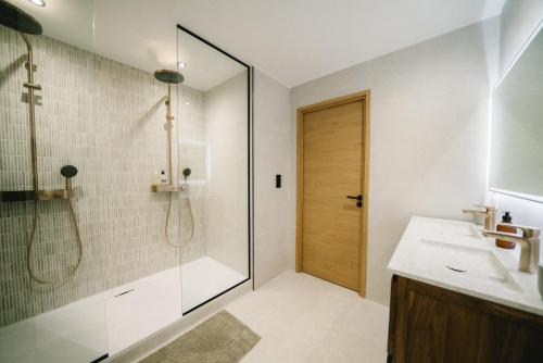 une salle de bain avec douche et porte vitrée dans l'établissement L'Écrin Annécien by ExplorHome, à Annecy