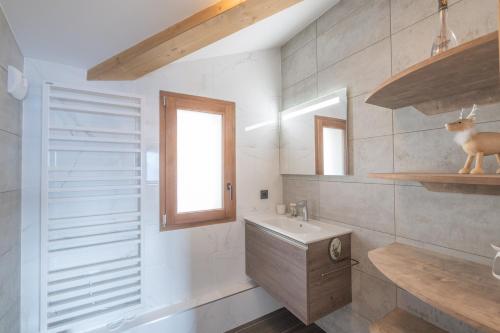 ein Badezimmer mit Waschbecken und Spiegel in der Unterkunft Alpe d'Huez Houses - Chez Emma - Fermes de l'Alpe - du cachet dans le vieil Alpe in L'Alpe-d'Huez