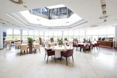 a dining room with tables and chairs and windows at Hotel Premier Aqua - Adults Only in Vrdnik