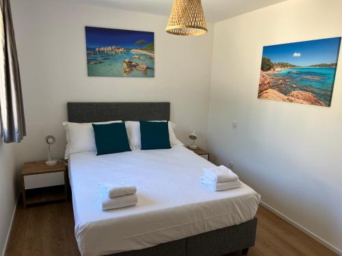 - une chambre avec un lit doté de draps blancs et d'oreillers bleus dans l'établissement Location T2 44 m2 proche plage Lecci appartement 82, à Lecci