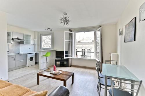 un salon avec un canapé et une table dans l'établissement Appartement Central Avenue du Maine - II, à Paris