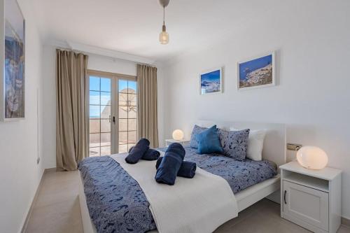 a bedroom with a bed with blue pillows on it at Seaside Apartment with Spacious Terrace, Pool, and Wi-Fi in Santa Cruz de Tenerife