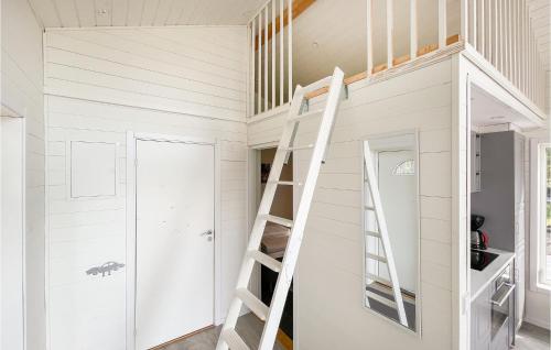 a white tiny house with a ladder in it at Nice Home In Hammarö With Kitchen in Gunnarskär
